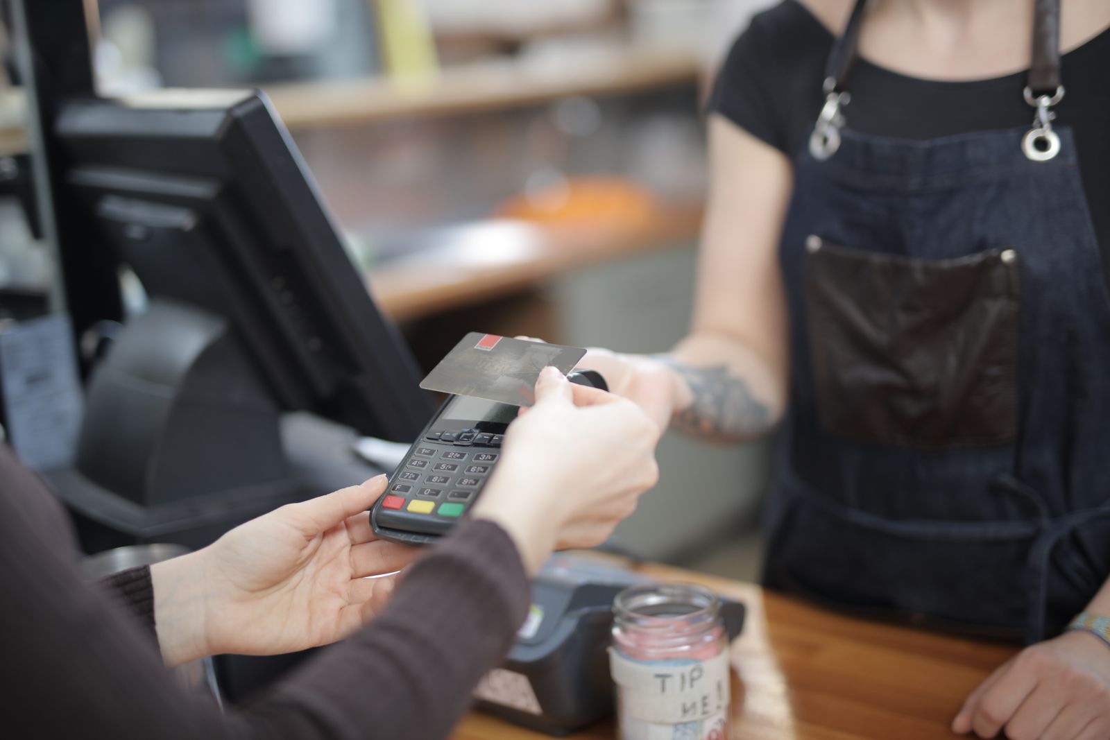 Customer making a card payment at a retail checkout terminal